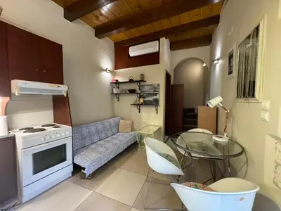a kitchen with a couch and a glass table at Casa Argirenia - Venetian Mansion in Old Harbour in Chania Town