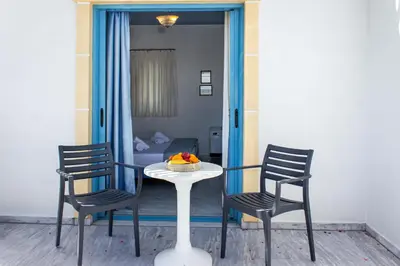 a table with two chairs and a table with a bowl of fruit on it at Blue Calm in Daratso