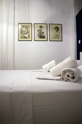 a white bed with three pictures on the wall at Superior Apartment Near Beach in Chania Town