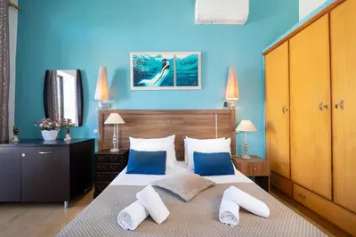 a bedroom with a large bed with blue walls at Irini Apartment I in Kalyves