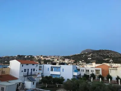 a group of white buildings with a mountain in the background at Paradise in Áyios Andhréas