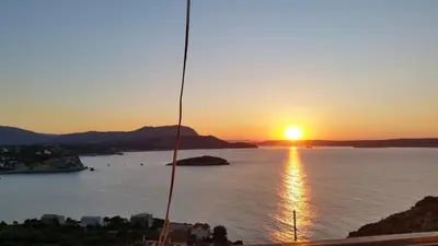 a sunset over a body of water with the sun setting at Paradise in Áyios Andhréas