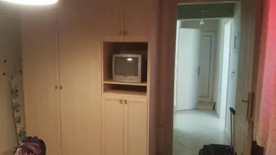 a room with a tv on a shelf with a hallway at Paradise in Áyios Andhréas