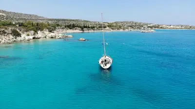 a white boat in the middle of a large body of water at Perseus Sailing Cruises in Souda