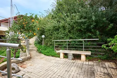 a bench sitting on a brick walkway next to a tree at Seaside House in Chania Town