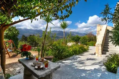 a stone bench sitting in a garden with a view at Villa Iro - Private Pool & Tranquility in Káïna