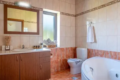 a bathroom with a tub and a toilet and a sink at Villa Kamaraki in Patellárion