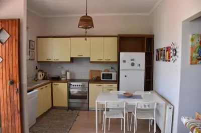 a kitchen with a table and chairs and a white refrigerator at Villa Gerani in Gerani Chanion