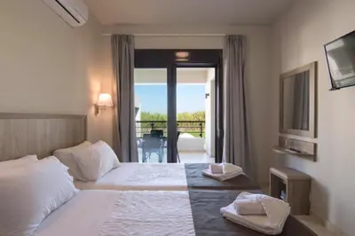 a hotel room with a bed and a balcony at Carisa Suites and Apartments in Maleme