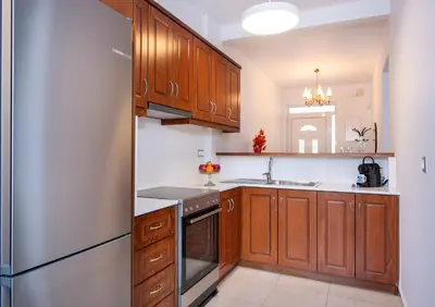 a kitchen with wooden cabinets and a stainless steel refrigerator at GreenView Chania Center Luxury Suite in Chania Town