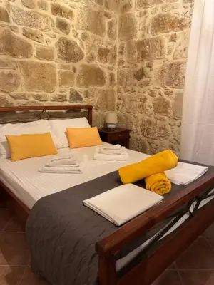 a bed with yellow and white pillows on it at Villa Antonia in Gramvousá