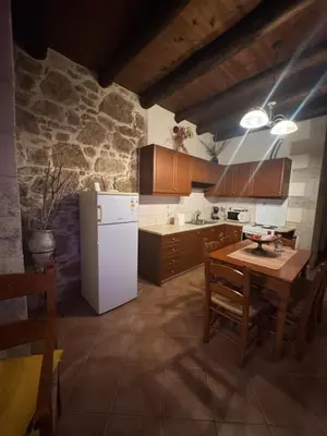 a kitchen with a table and a white refrigerator at Villa Antonia in Gramvousá