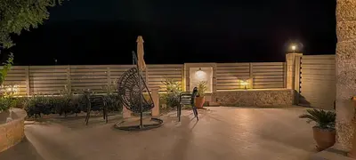 a patio with chairs and a fence at night at Achlades The Mountain Paradise Villas - Studio with pool! in Aletrouvárion