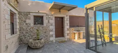 a house with a glass door and a potted plant at Achlades The Mountain Paradise Villas - Studio with pool! in Aletrouvárion