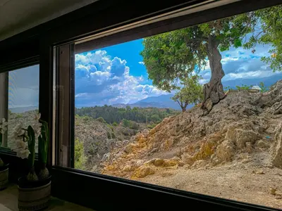 a window with a view of a tree on a hill at Achlades The Mountain Paradise Villas - Suite with pool and balcony with amazing view! in Aletrouvárion