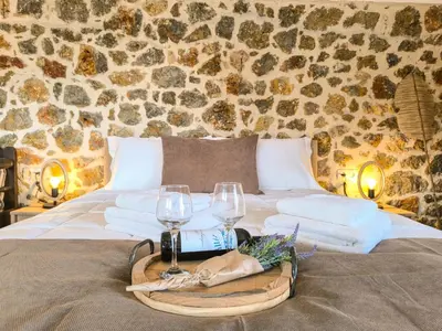 a bed with two glasses and a tray with towels at Achlades The Mountain Paradise Villas - Suite with pool and balcony with amazing view! in Aletrouvárion