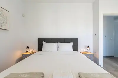 a bedroom with a large white bed with two lamps at Menta Villa by Vintage Travel in Tavronitis