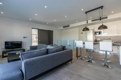 a living room with a couch and a television at Menta Villa by Vintage Travel in Tavronitis
