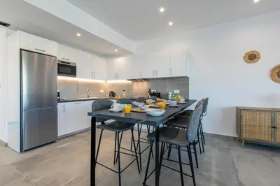 a kitchen with a table with chairs and a refrigerator at Myrtle Villa by Vintage Travel in Tavronitis