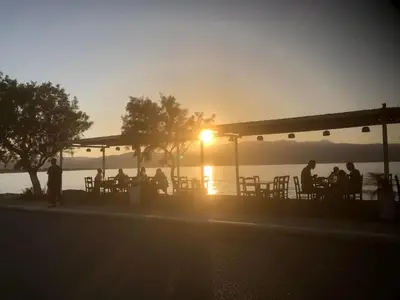 a group of people sitting at a bar at sunset at Diktamos Villa by Vintage Travel in Tavronitis