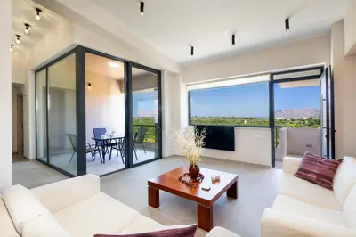 a living room with white furniture and large windows at Didas Serenity Breeze in Kounoupidhianá