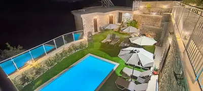 an aerial view of a house with a pool and umbrellas at Achlades The Mountain Paradise Villas - Suite with a Private Jacuzzi, Pool, and a Balcony with an Amazing View! in Aletrouvárion