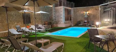 a swimming pool in a yard with chairs and an umbrella at Achlades The Mountain Paradise Villas - Suite with a Private Jacuzzi, Pool, and a Balcony with an Amazing View! in Aletrouvárion
