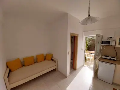 a living room with a couch with orange pillows at Nik Litinas Apartments with pool in Plataniás