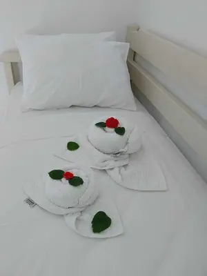 a white bed with towels on top of it at Nik Litinas Apartments with pool in Plataniás