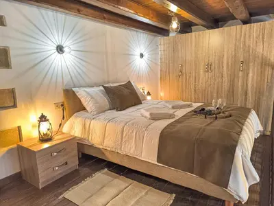 a bedroom with a large bed and a wooden wall at Achlades The Mountain Paradise Villas - Maisonette with pool and amazing view! in Aletrouvárion