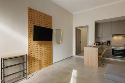 a kitchen and a living room with a tv on a wall at Callista City Living III in Chania Town