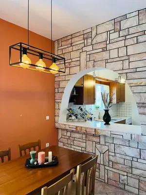 a kitchen with a table and a stone wall at Villa Domenico in Vryses