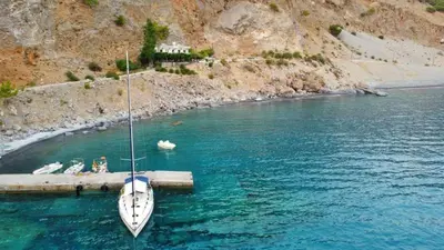 a boat tied to a dock in a body of water at Sweet Corner Masxali in Agia Roumeli