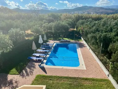 an overhead view of a swimming pool with chairs and umbrellas at Bellavista Gardens Skoutelonas in Skoutelónas