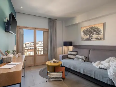 a living room with a couch and a desk at Elia Bettolo Hotel in Chania Town