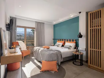 a bedroom with a bed and a blue wall at Elia Bettolo Hotel in Chania Town