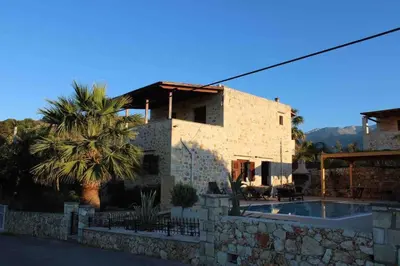 a house with a palm tree and a swimming pool at Villa Aris in Crete with private pool en private parking! in Neo Chorio