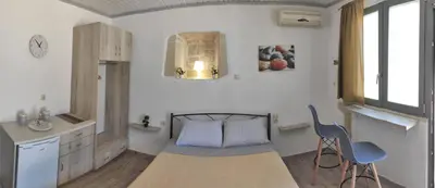 a bedroom with a bed and a table and chairs at Bee studio in Gavalochori