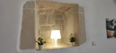 a lamp in a stone window with two potted plants at Bee studio in Gavalochori