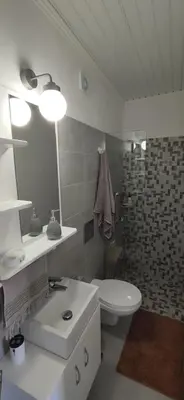 a white bathroom with a sink and a toilet at Bee studio in Gavalochori