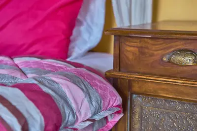 a close up of a bed with a wooden dresser and a night stand at Villa Evenos with private pool in Elafonisi