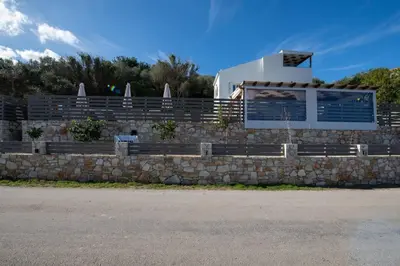 a stone retaining wall with a building in the background at Villa Mareli - Beachside Villa with Heated Pool in Almirida
