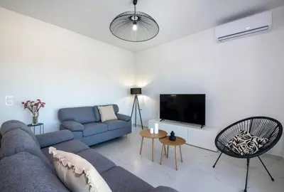 a living room with a blue couch and a tv at Villa Pervana- Private pool - Close to the Beach in Arménoi