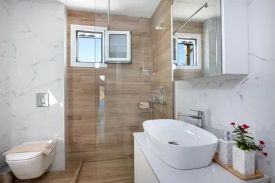 a bathroom with a white sink and a toilet at Villa Pervana- Private pool - Close to the Beach in Arménoi