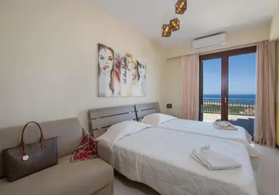a bedroom with a bed and a couch and a window at Marilia by Vintage Travel in Maleme