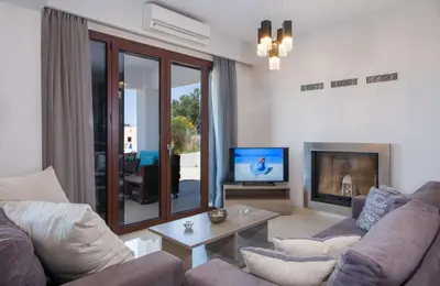 a living room with a couch and a tv at Marilia by Vintage Travel in Maleme