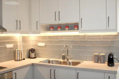a kitchen with a sink and white cabinets at Nerina Home Chania in Chania Town