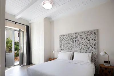 a white bedroom with a large bed and a window at Artemis Apollonas Villa I Luxury Escape with Pool in Káïna