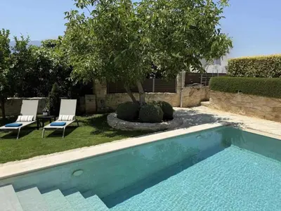a swimming pool with two chairs and a tree at Artemis Apollonas Villa I Luxury Escape with Pool in Káïna