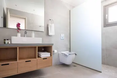 a bathroom with a sink and a toilet and a mirror at Villa Eva Chania in Neo Chorio